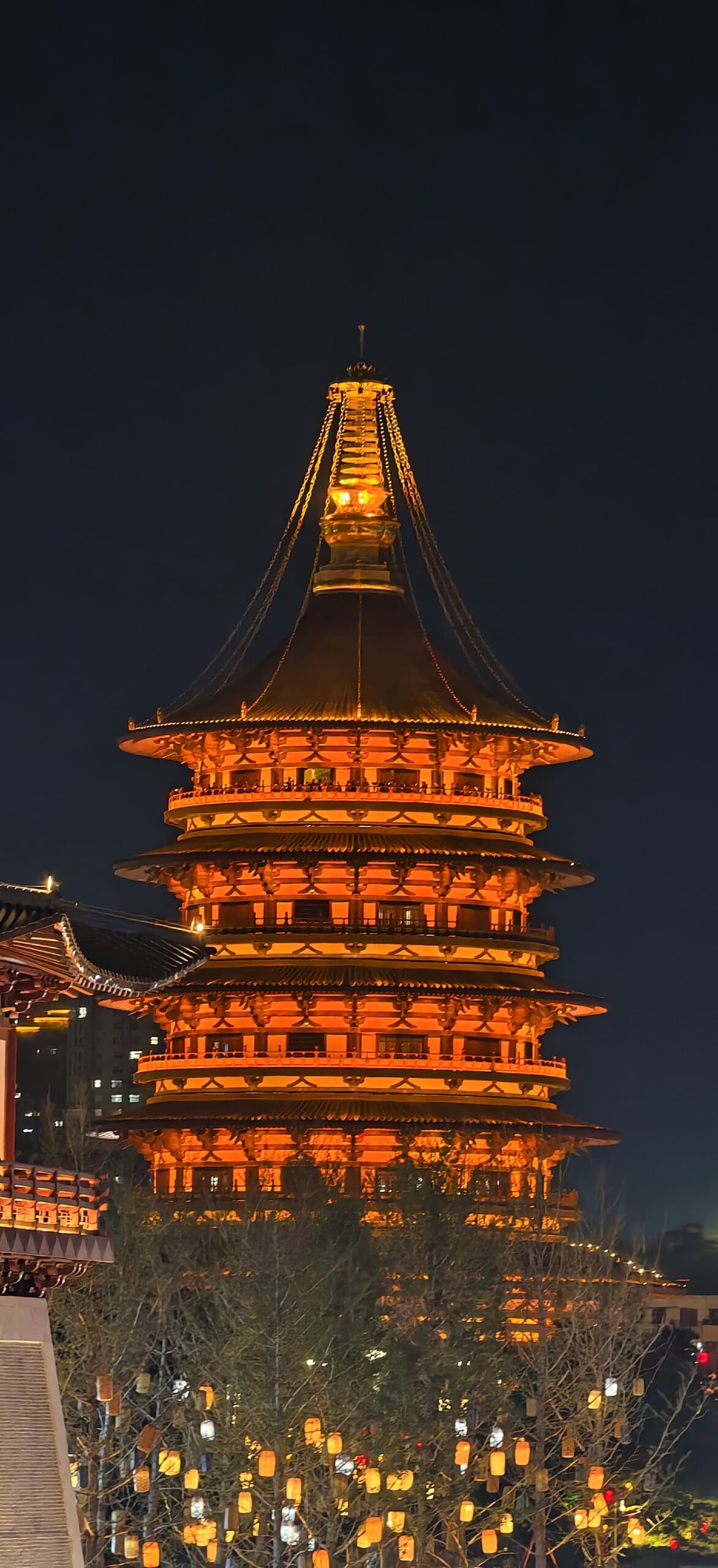 天堂圆塔在夜空中逐级升高，金顶如火焰向上收束