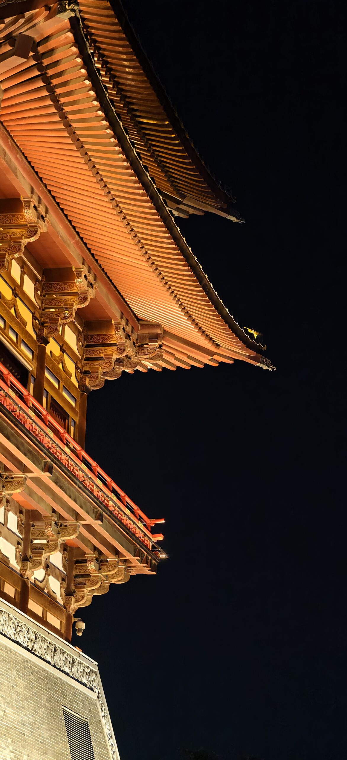 另一侧檐廊的近景：红柱、斗拱与深墨的夜空构成对比