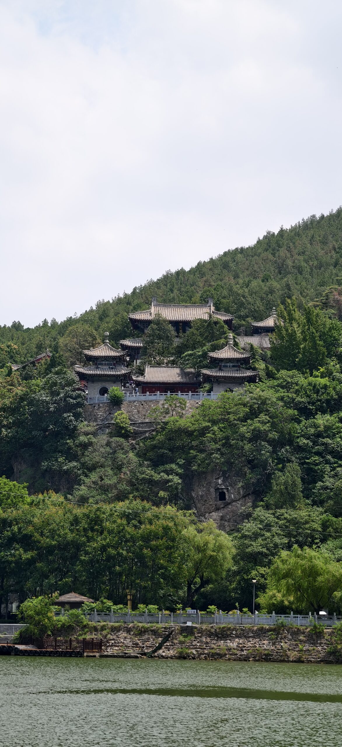 对岸香山寺依坡而建，殿宇藏在绿树与伊河之间