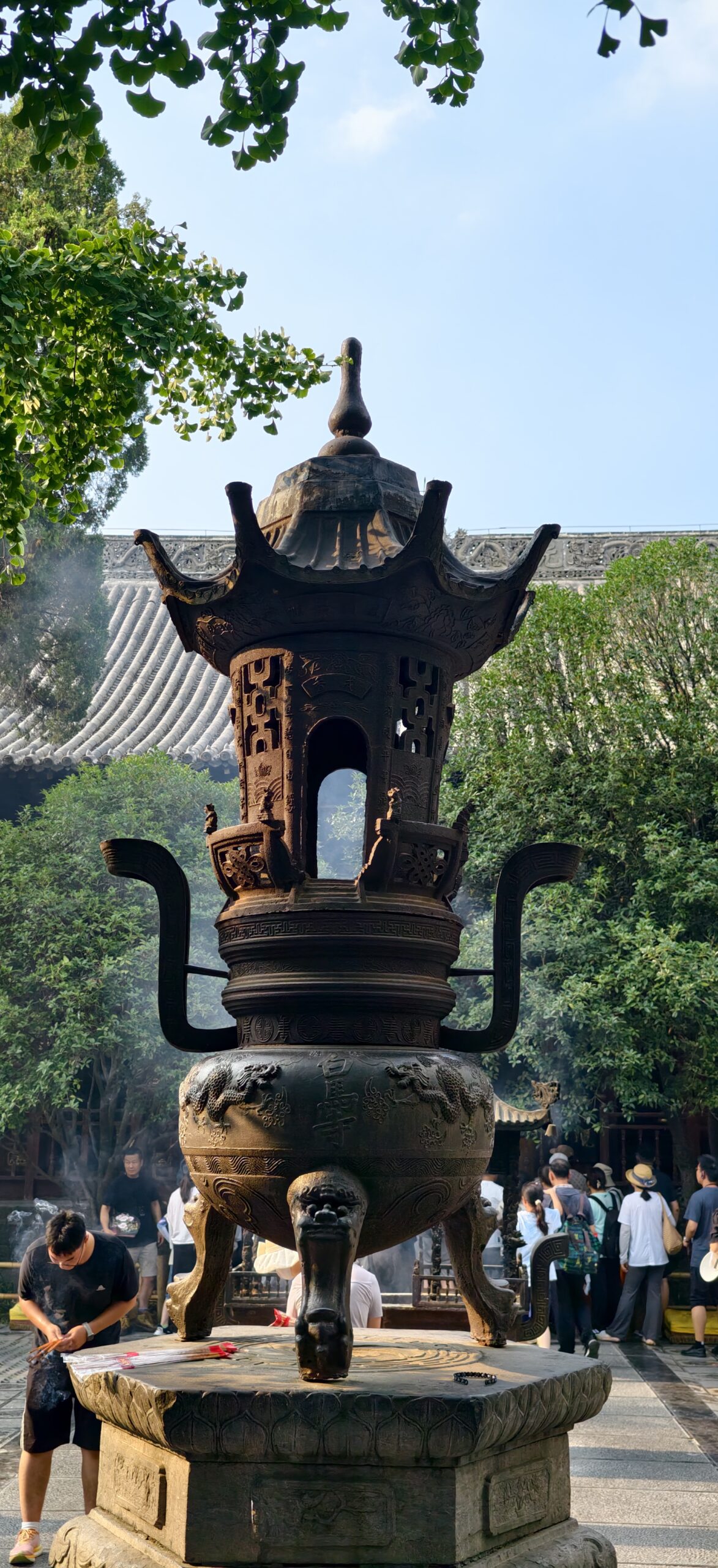寺内通道向前延伸，檐角与栏杆在浓绿中显出层次