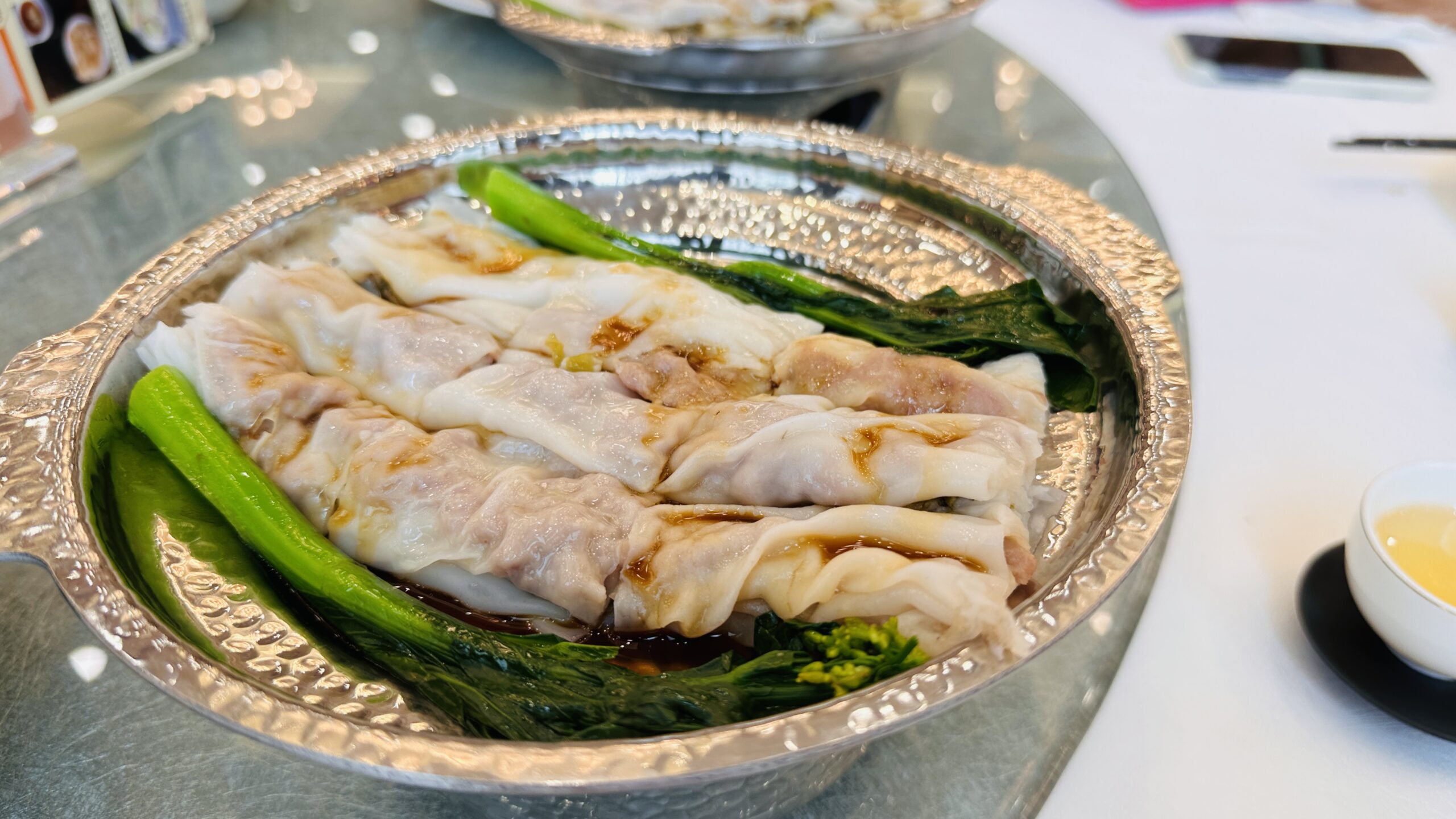 透明粉皮卷着肉馅，旁边配有一把翠绿时蔬。