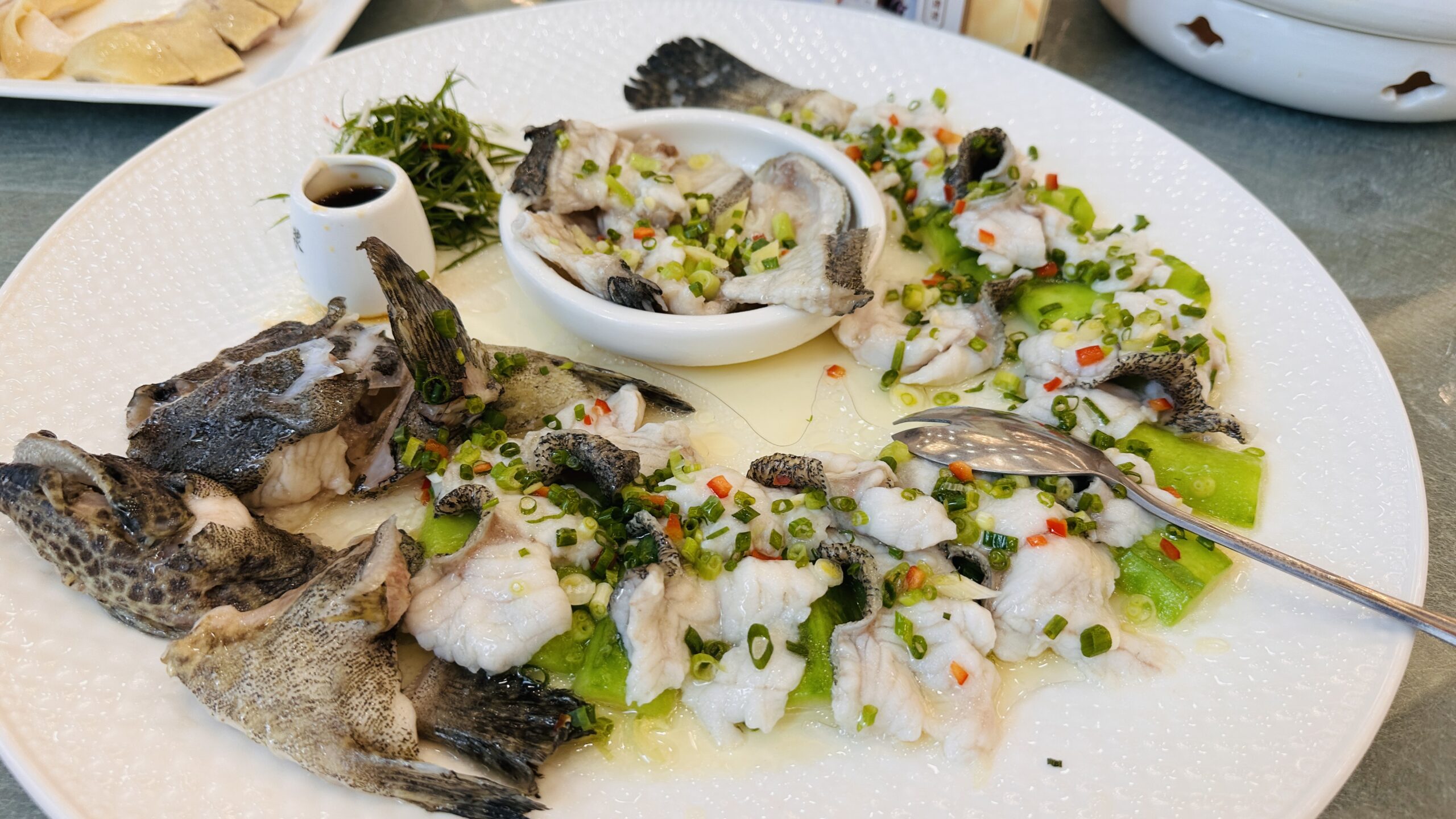 石斑鱼起肉成片，配丝瓜垫底与白切鸡同席。