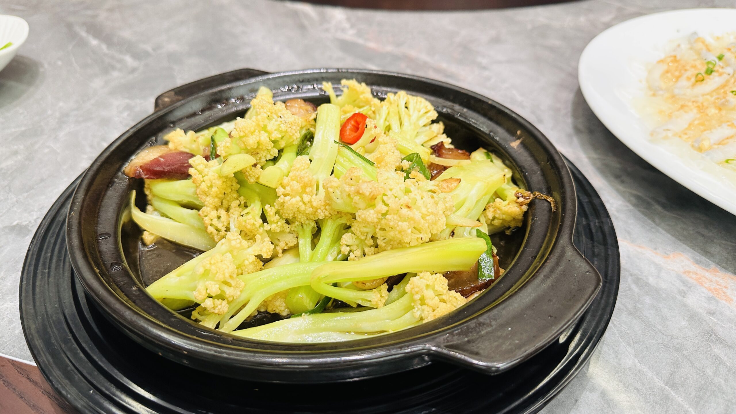 腊味花菜煲里菜花爽脆，腊肉片油香四溢。