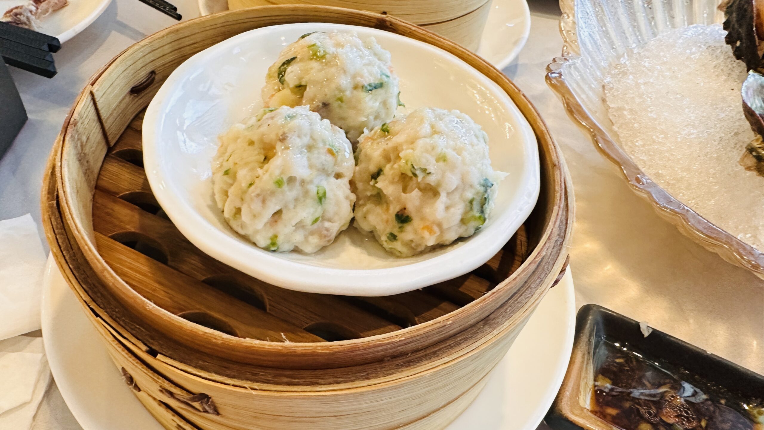 竹蒸笼里三颗鲮鱼球，是顺德手打鱼滑的常见做法。