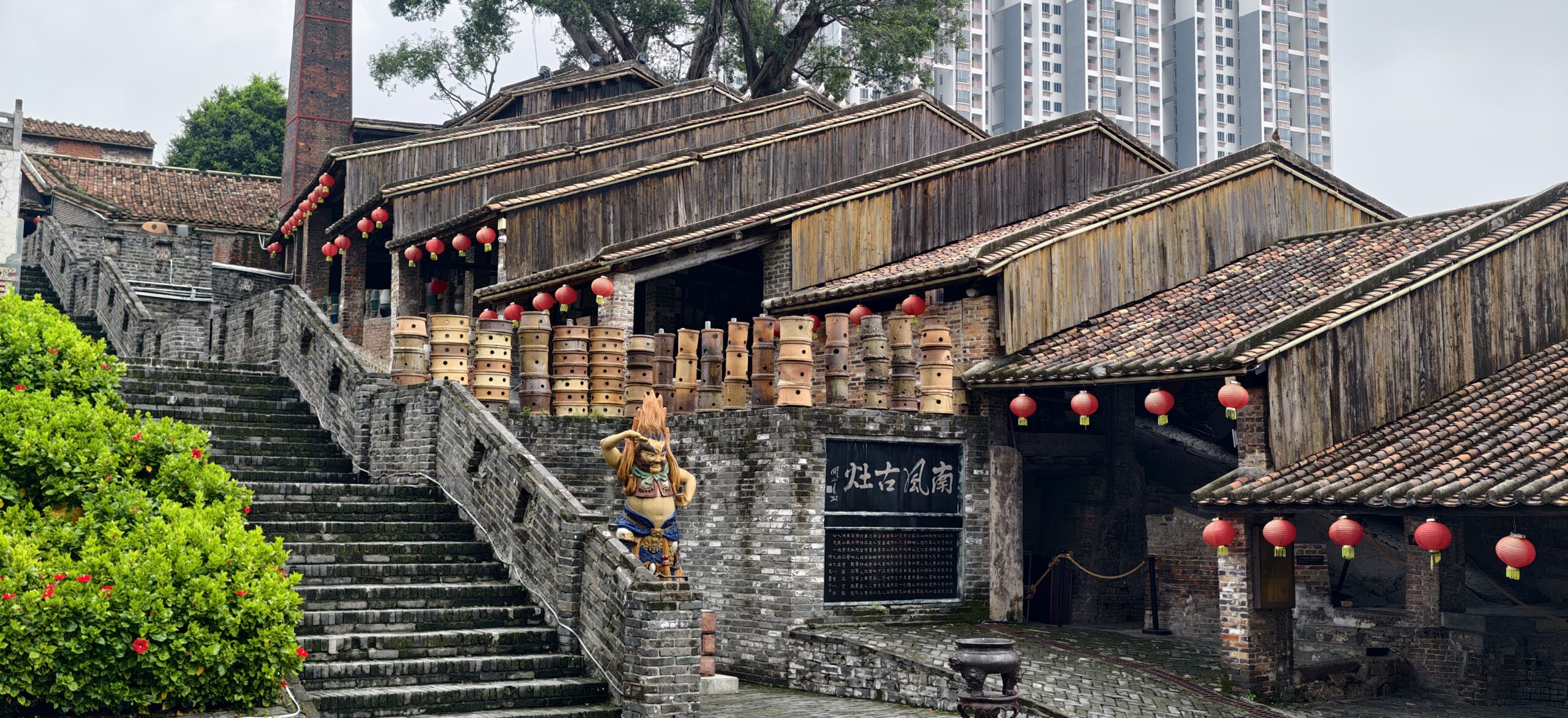 南风古灶主体全景沿坡展开，古窑、瓦房与红灯笼尽收眼底。