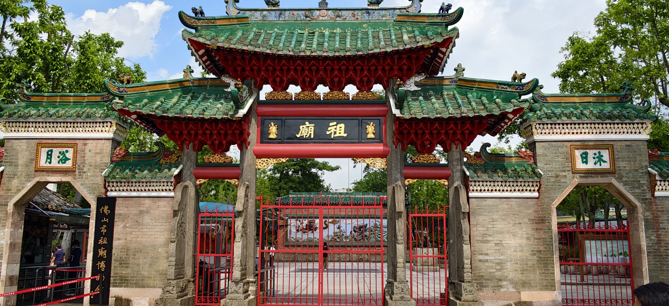 祖庙正门全景，绿琉璃瓦门楼下悬着金字祖庙匾额。