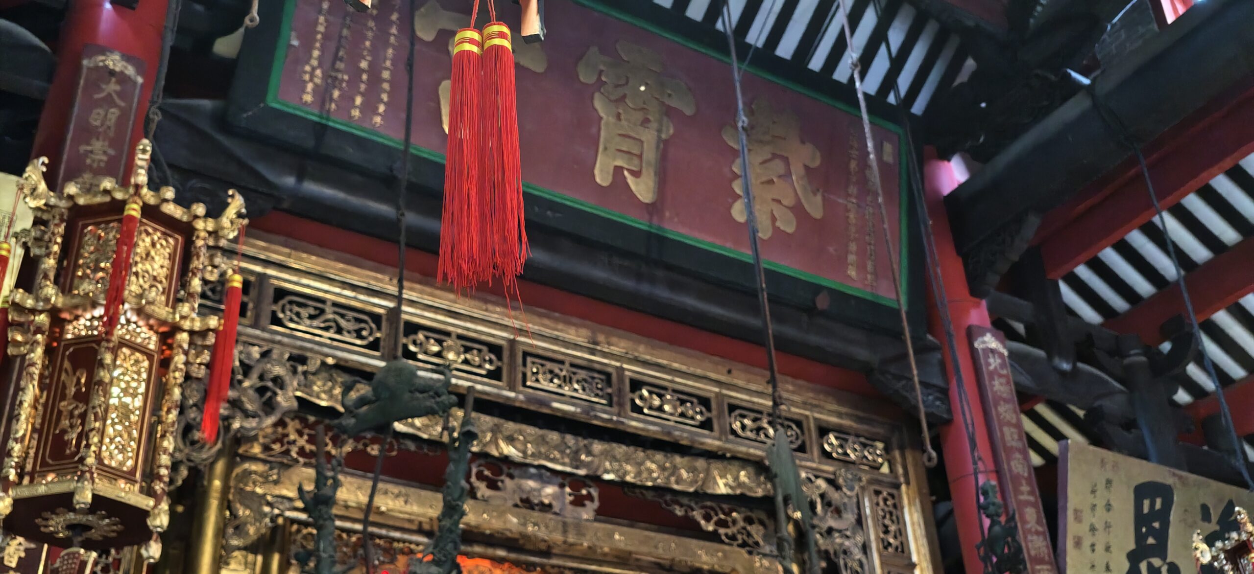 昏暗殿内悬着红穗宫灯，后方匾额题有风调雨顺。
