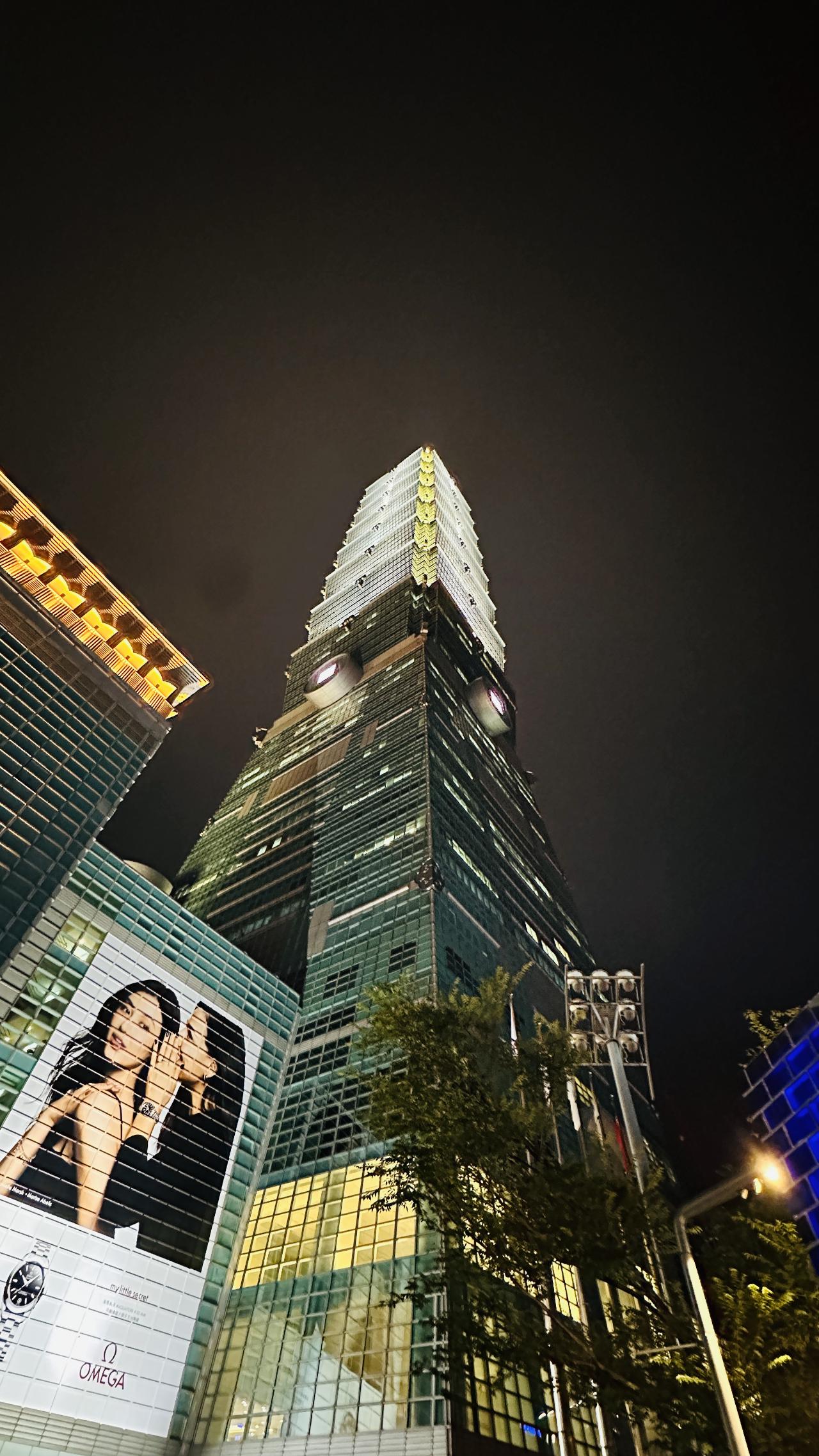 夜色中的101外墙和入口灯光，把现代商圈照得很冷